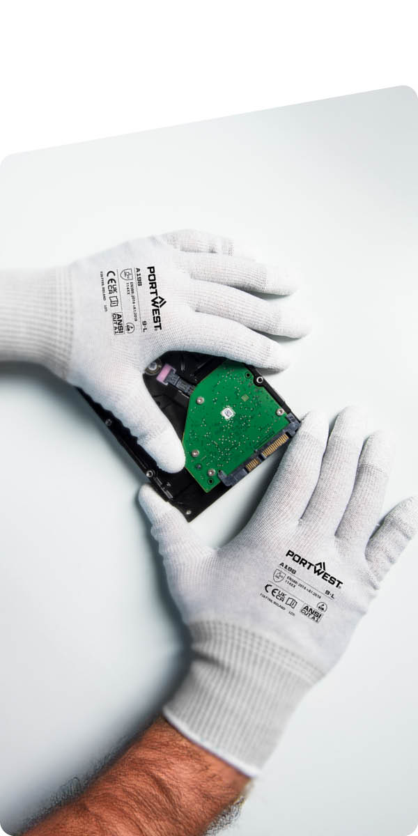 Manos con guantes ESD Portwest manipulando un disco duro. Manos con guantes ESD Portwest manipulando un disco duro.